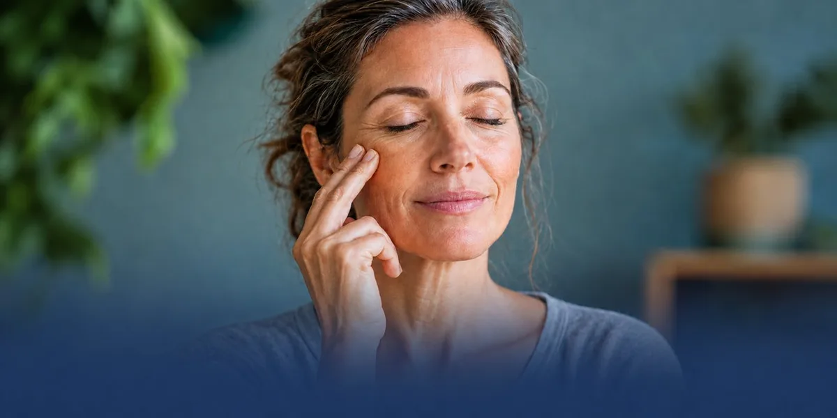 Woman with eyes closed tapping beside her eye